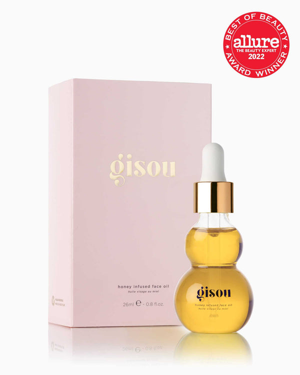A bottle of Honey Infused Face Oil next to pink carton packaging with the award winning allure sticker
